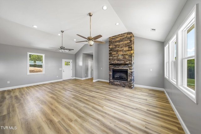 2137 Rainwater Rd, Dandridge, TN 37725 - unfurnished living room with vaulted ceiling, light wood-style floors, a stone fireplace, baseboards, and ceiling fan