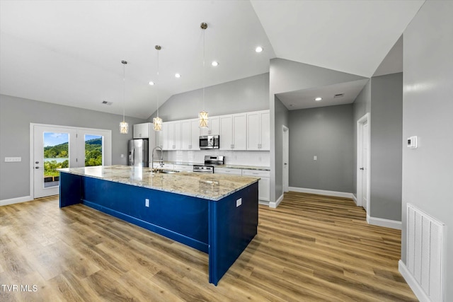 2137 Rainwater Rd, Dandridge, TN 37725 - kitchen with stainless steel appliances, a sink, white cabinetry, a spacious island, and light wood-type flooring