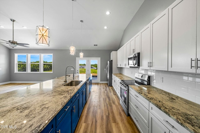 kitchen featuring appliances with stainless steel finishes, white cabinets, blue cabinetry, a wealth of natural light, and sink