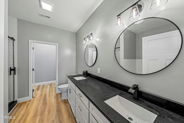 bathroom featuring an enclosed shower, vanity, toilet, and hardwood / wood-style flooring