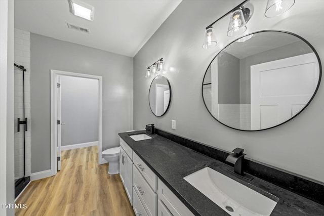2137 Rainwater Rd, Dandridge, TN 37725 - full bathroom with wood finished floors, double vanity, a shower, toilet, and baseboards