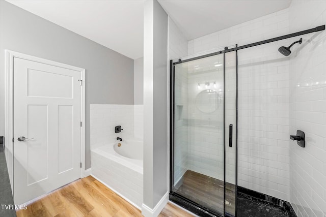 bathroom featuring separate shower and tub and hardwood / wood-style floors