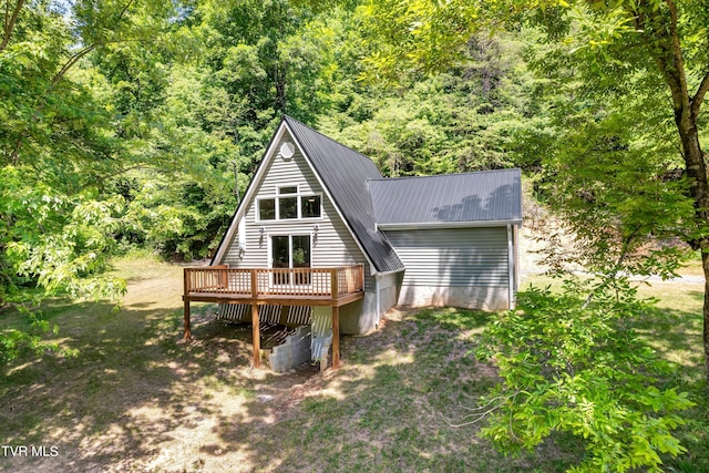 back of property featuring a lawn and a deck