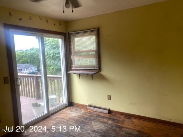 spare room featuring ceiling fan, a baseboard radiator, and plenty of natural light