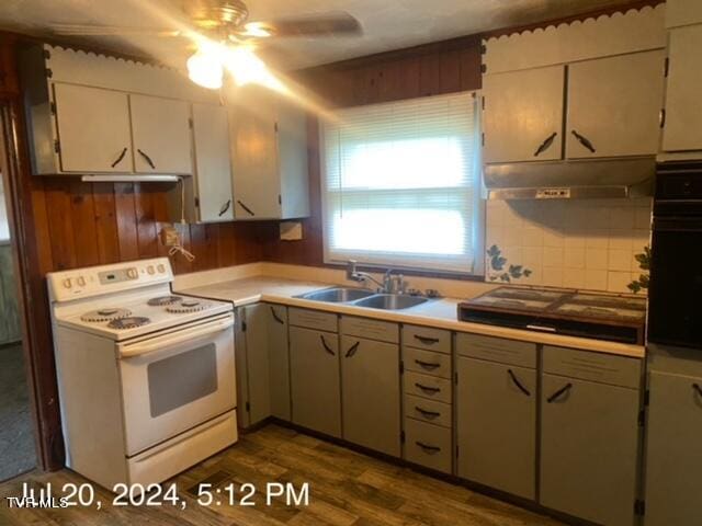 kitchen with ceiling fan, sink, black oven, electric range, and dark hardwood / wood-style flooring