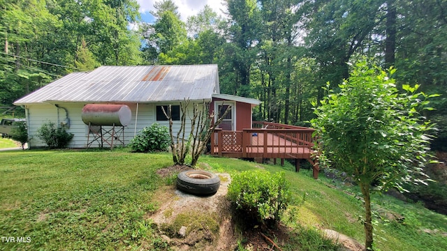 view of front of house with an outdoor fire pit, a deck, and a front lawn