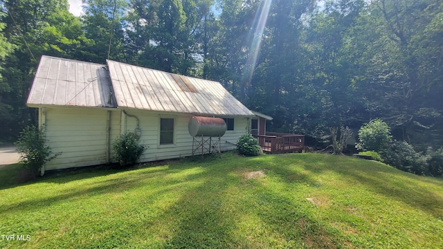 view of home's exterior featuring a wooden deck and a lawn