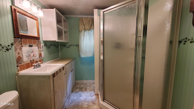 bathroom featuring vanity, tasteful backsplash, toilet, and walk in shower