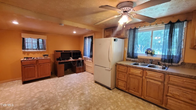 kitchen featuring sink, ceiling fan, a textured ceiling, and white fridge