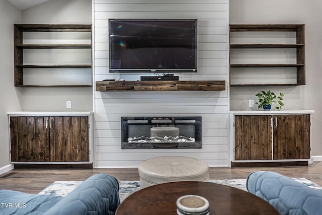 living room with wood-type flooring, a large fireplace, and vaulted ceiling