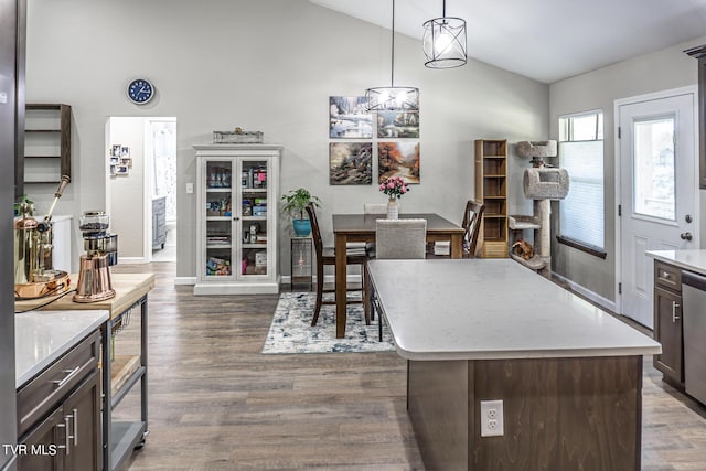 kitchen with pendant lighting, a center island, vaulted ceiling, dark hardwood / wood-style floors, and dark brown cabinets