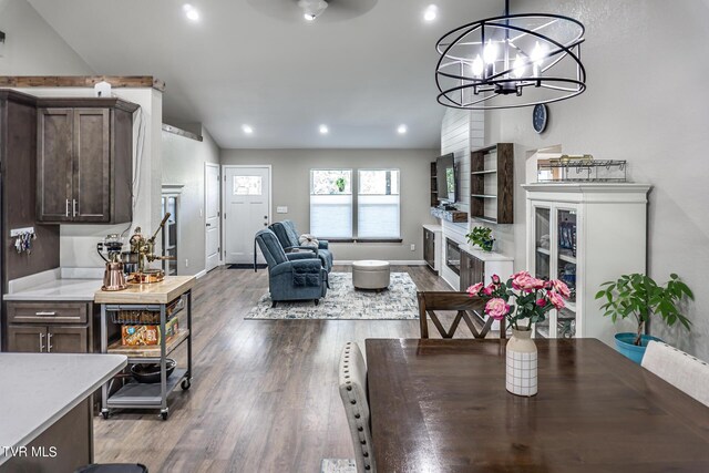 dining space with dark hardwood / wood-style flooring, an inviting chandelier, and lofted ceiling