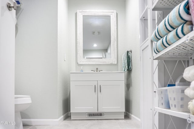 bathroom featuring toilet, vanity, and tile patterned floors