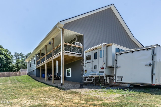 rear view of house featuring a deck and a lawn