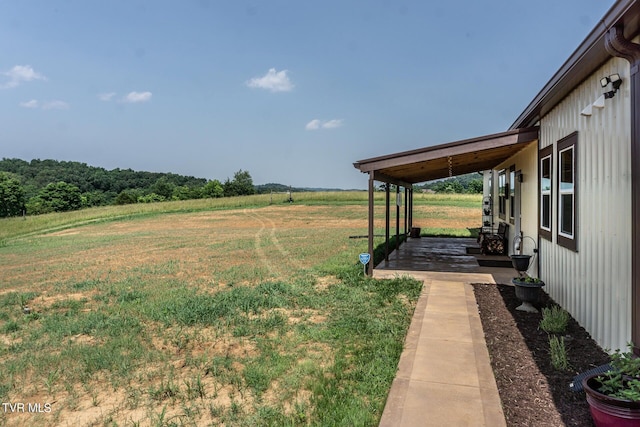 view of yard featuring a rural view and covered porch