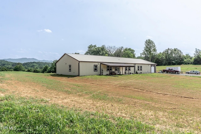 view of front of house featuring a mountain view and a front lawn