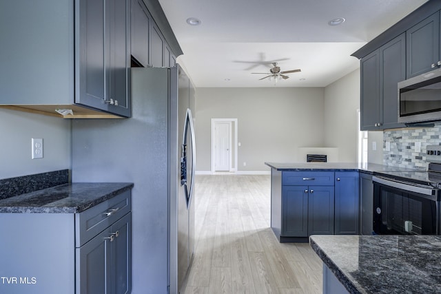 kitchen featuring backsplash, ceiling fan, light wood-type flooring, appliances with stainless steel finishes, and kitchen peninsula