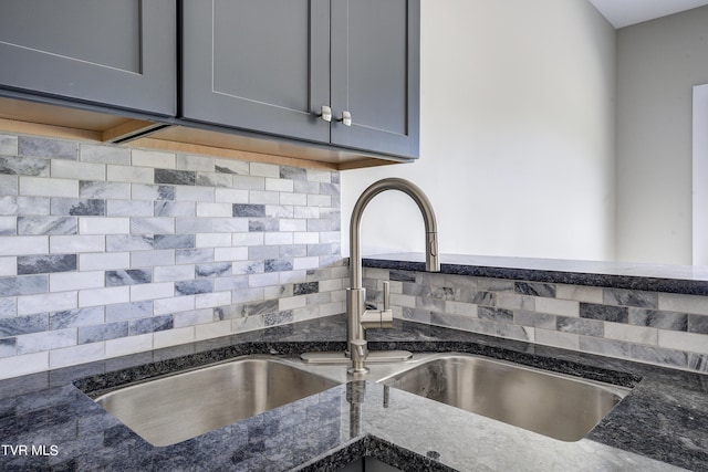 kitchen with tasteful backsplash, sink, and dark stone counters