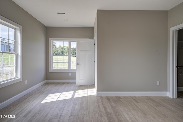 unfurnished room featuring light hardwood / wood-style flooring and plenty of natural light