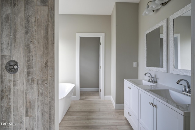 bathroom featuring hardwood / wood-style floors, a washtub, and vanity