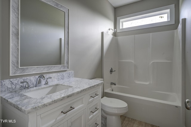 full bathroom with shower / washtub combination, vanity, wood-type flooring, and toilet