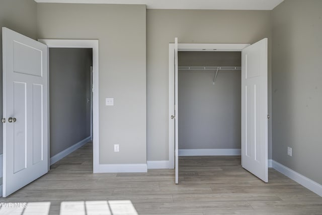 unfurnished bedroom featuring a closet and light hardwood / wood-style floors