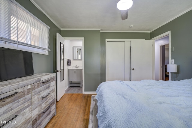 bedroom with ornamental molding, ceiling fan, light hardwood / wood-style flooring, connected bathroom, and a closet