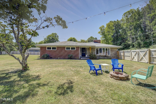 back of property featuring a yard and a fire pit