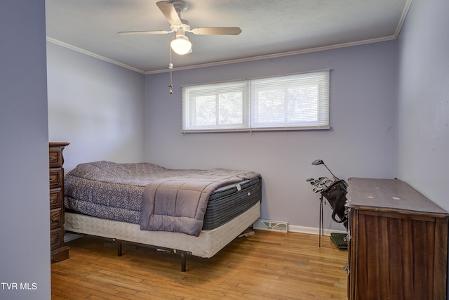 bedroom featuring light hardwood / wood-style flooring, ceiling fan, and crown molding