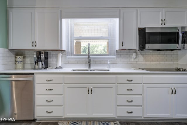 kitchen featuring backsplash, white cabinetry, sink, and appliances with stainless steel finishes