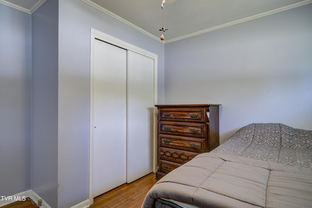 bedroom featuring light hardwood / wood-style flooring, a closet, and ornamental molding