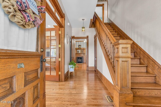 308 E Pearl Ave, Big Stone Gap, VA 24219 - foyer featuring stairway, light wood-style floors, and a glass covered fireplace