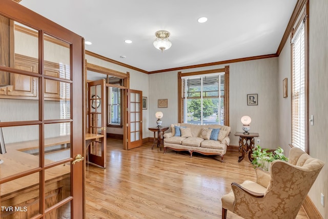 living room with ornamental molding, light hardwood / wood-style flooring, and french doors