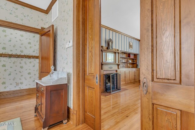 308 E Pearl Ave, Big Stone Gap, VA 24219 - bathroom featuring wallpapered walls, wood finished floors, ornamental molding, and a fireplace with flush hearth