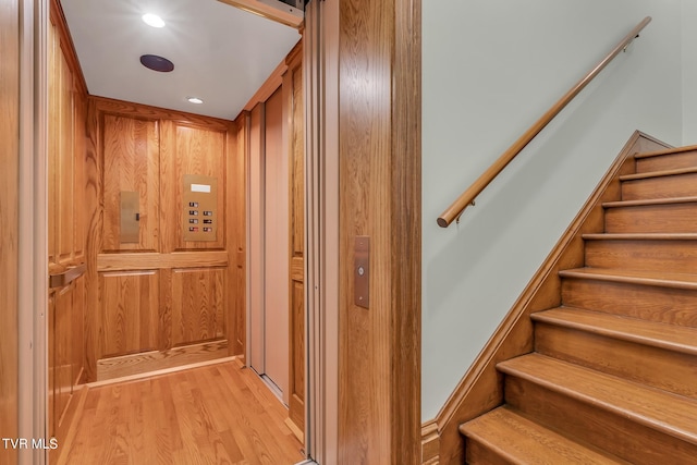 room details featuring wood walls, hardwood / wood-style flooring, and elevator