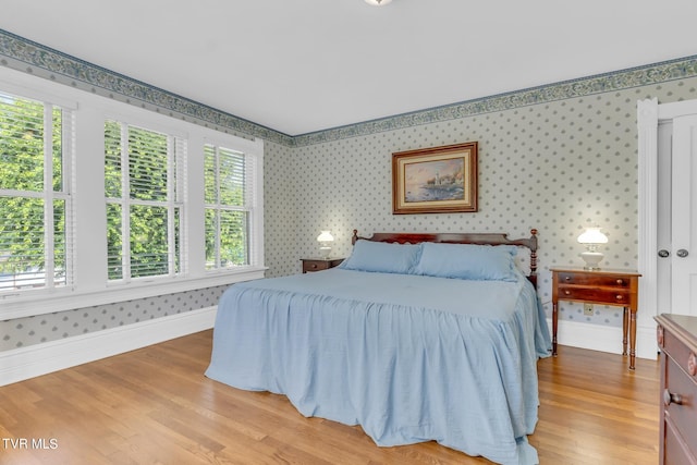 bedroom with multiple windows and light hardwood / wood-style floors