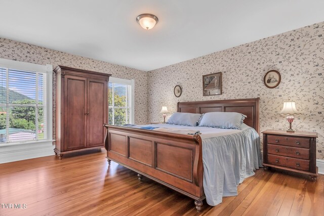 308 E Pearl Ave, Big Stone Gap, VA 24219 - bedroom with wallpapered walls and light wood-type flooring