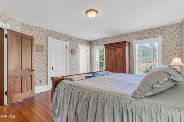 308 E Pearl Ave, Big Stone Gap, VA 24219 - bedroom with wallpapered walls, wood finished floors, and multiple windows