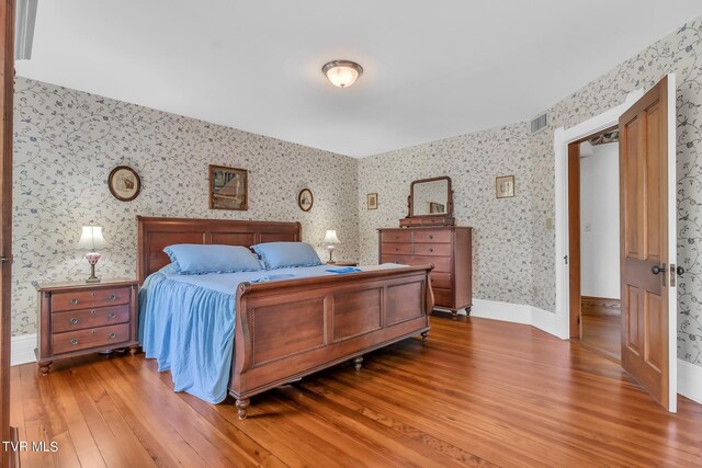 308 E Pearl Ave, Big Stone Gap, VA 24219 - bedroom with light wood-type flooring and wallpapered walls