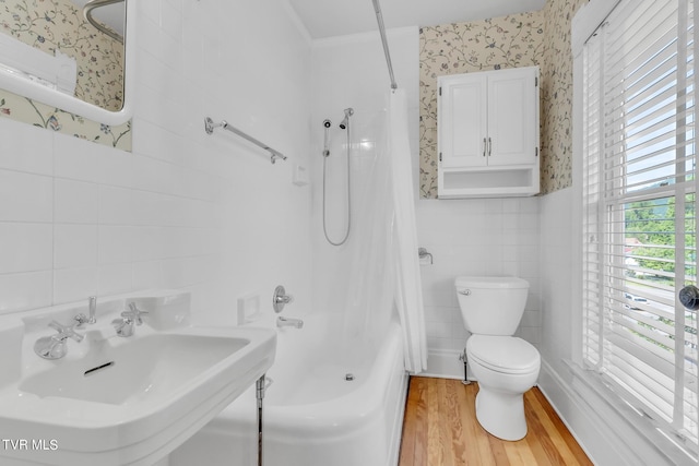 full bathroom with tile walls, shower / bath combo, sink, hardwood / wood-style flooring, and toilet