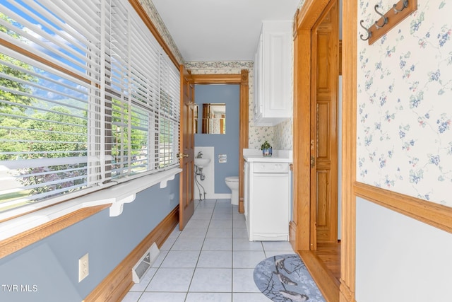 corridor with a healthy amount of sunlight and light tile floors