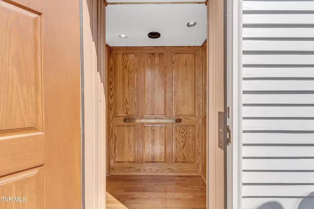 interior details with hardwood / wood-style floors and elevator