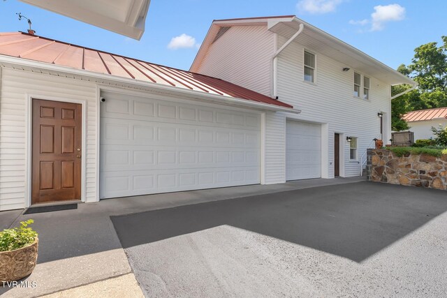 308 E Pearl Ave, Big Stone Gap, VA 24219 - view of property exterior featuring a standing seam roof, a garage, driveway, and a metal roof