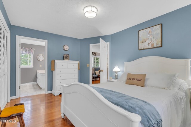308 E Pearl Ave, Big Stone Gap, VA 24219 - bedroom with wood finished floors, a closet, and connected bathroom