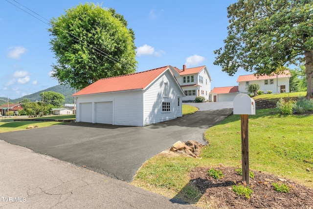 view of front of property with a front yard, an outdoor structure, and a garage