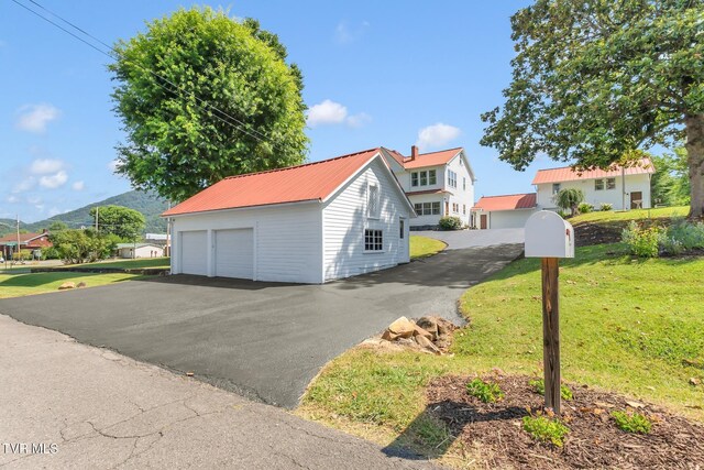 308 E Pearl Ave, Big Stone Gap, VA 24219 - view of home's exterior featuring a detached garage, a metal roof, a lawn, and an outdoor structure