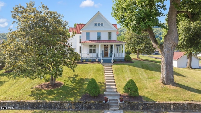 victorian home featuring a front lawn and a porch