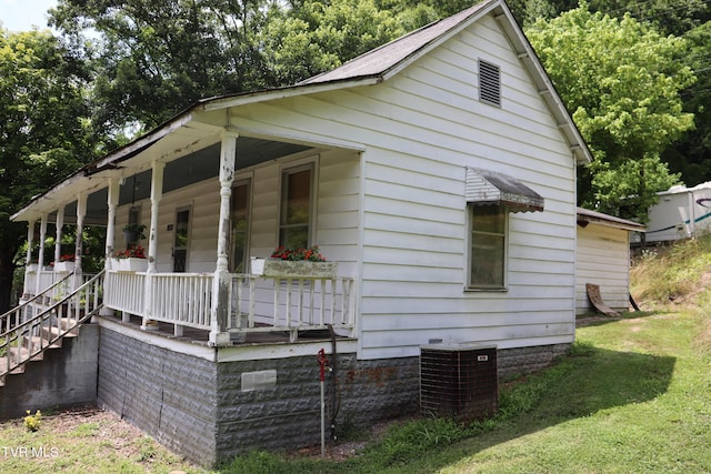 view of property exterior featuring central AC, a yard, and covered porch