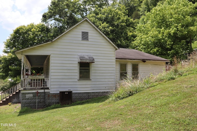 view of side of home with a yard and cooling unit