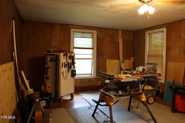 misc room with a workshop area and wood walls